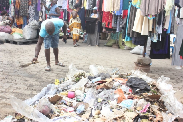 A stallholder gathers the plastic waste from the market in Douala, Cameroon